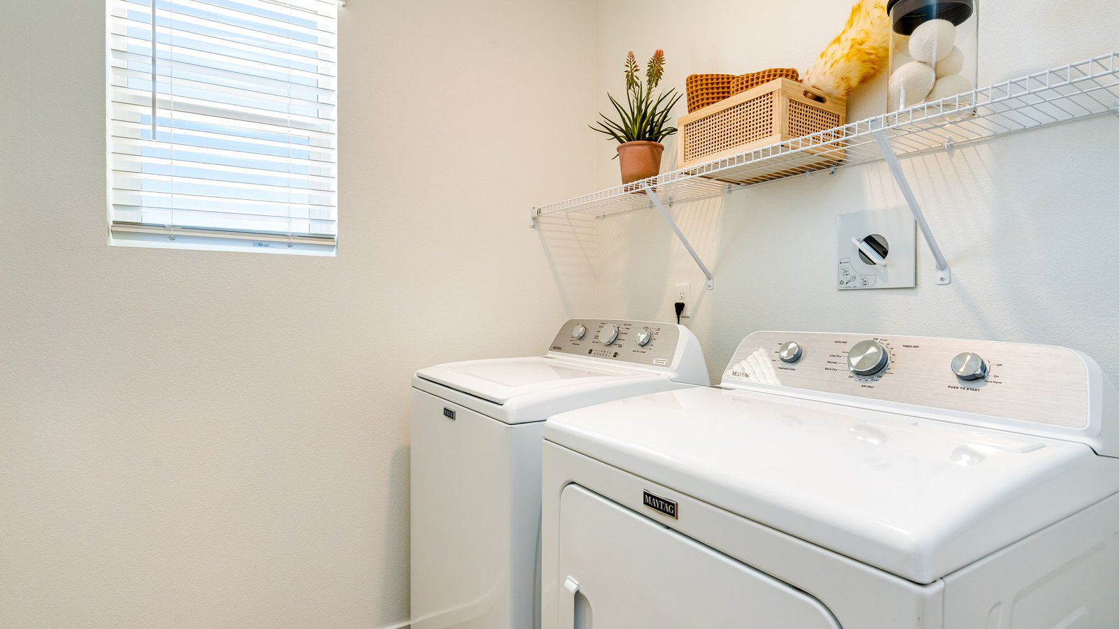 Laundry room with wire shelves and washer and dryer hookups