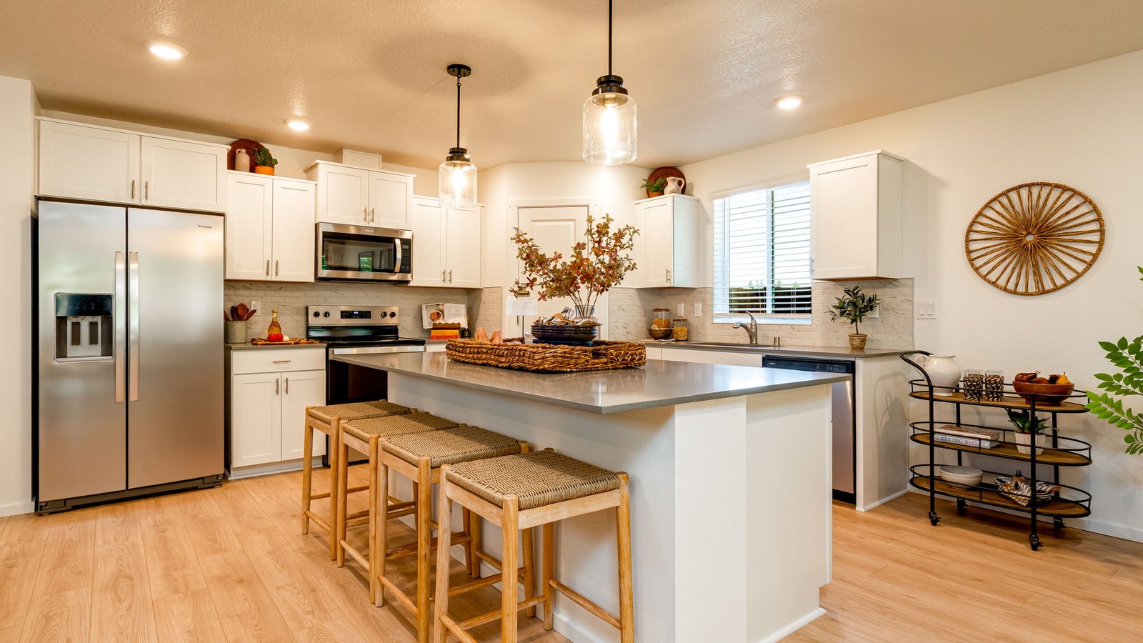 Kitchen with shaker cabinets, quartz counters, stainless steel appliances, pantry, and an island with a breakfast bar