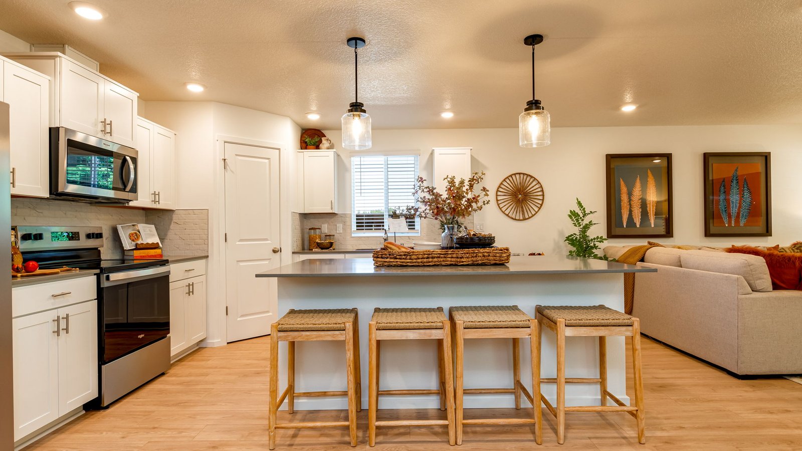 Kitchen with shaker cabinets, quartz counters, stainless steel appliances, pantry, and an island with a breakfast bar