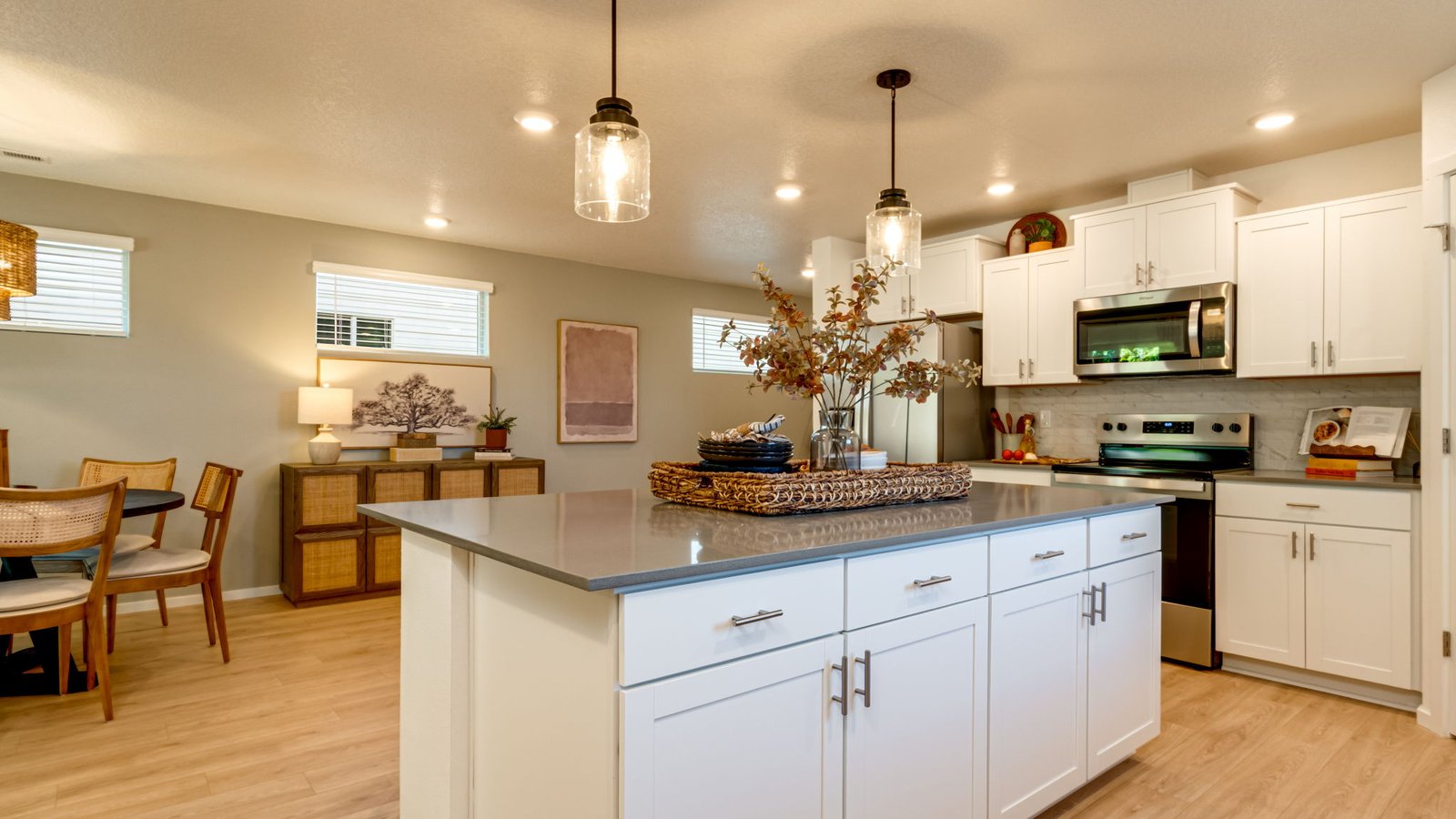 Kitchen with shaker cabinets, quartz counters, stainless steel appliances, pantry, and an island with a breakfast bar