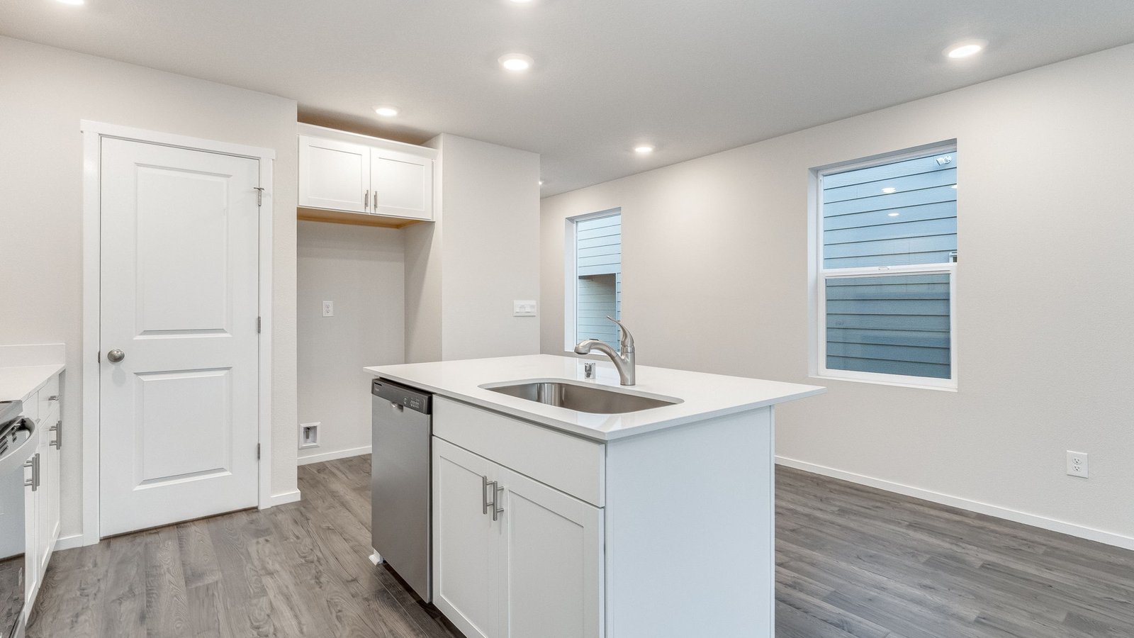 Kitchen with shaker cabinets, quartz counters, stainless steel appliances, pantry, and an island with a breakfast bar