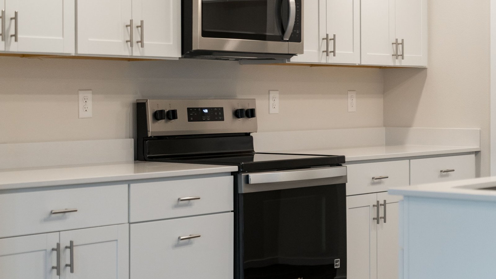Kitchen with shaker cabinets, quartz counters, stainless steel appliances, pantry, and an island with a breakfast bar