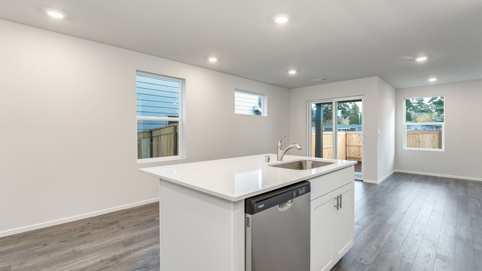 Kitchen with shaker cabinets, quartz counters, stainless steel appliances, pantry, and an island with a breakfast bar