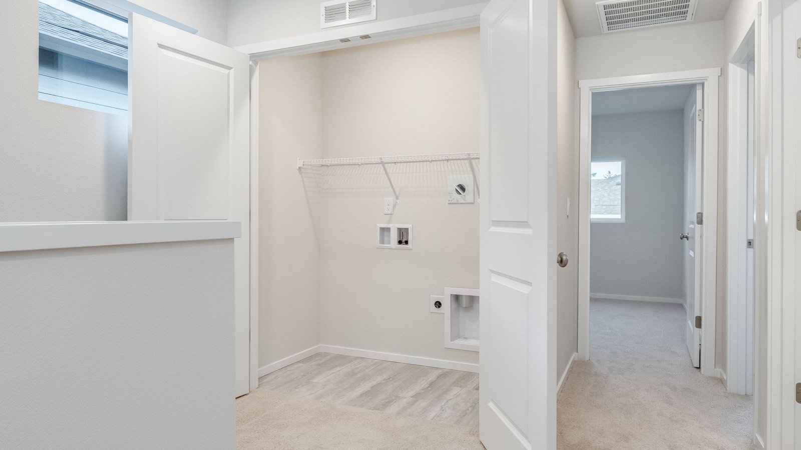Laundry closet with wire shelves and washer and dryer hookups