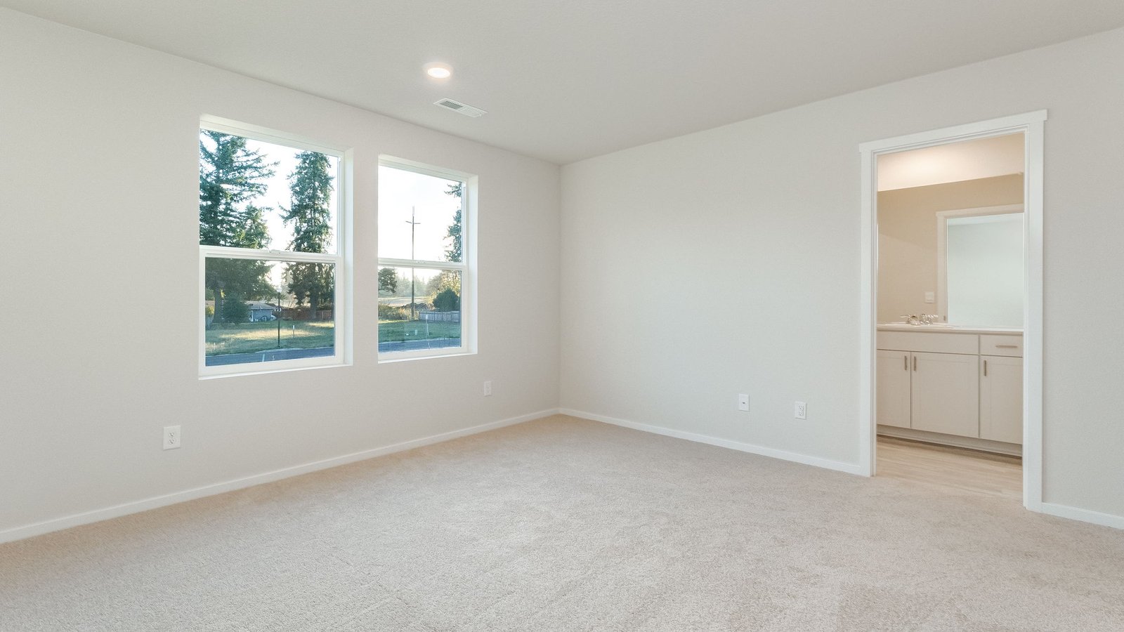 Primary bedroom with wall-to-wall carpet, a walk-in closet and an attached bathroom