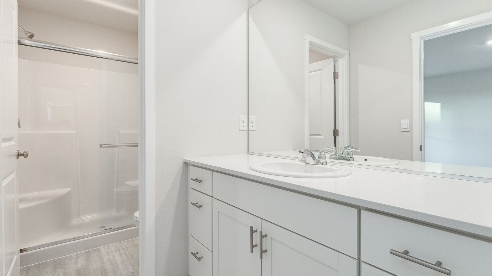 Primary bathroom with quartz counters and a walk-in shower
