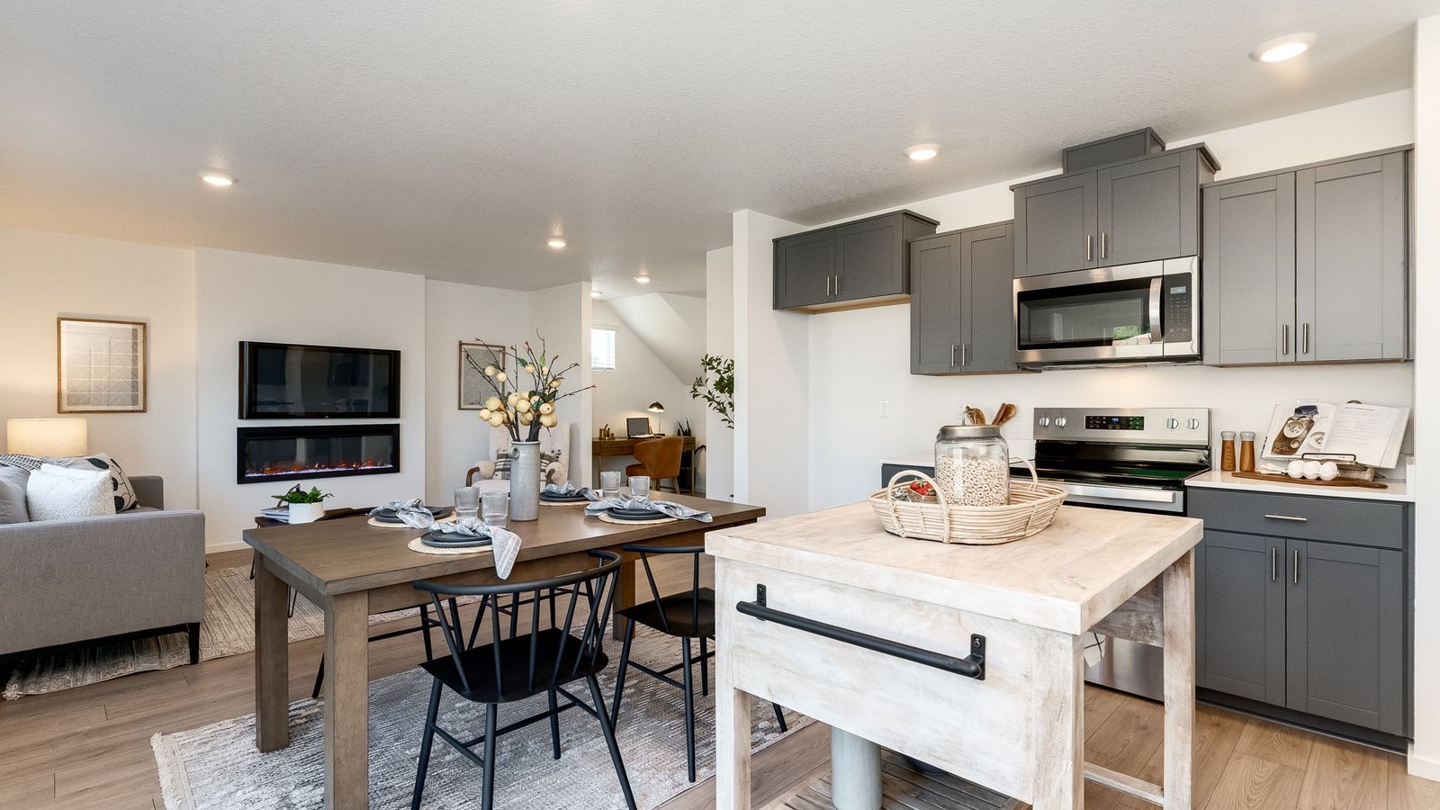 L-shaped kitchen with shaker cabinets, quartz counters, stainless steel appliances, and a pantry