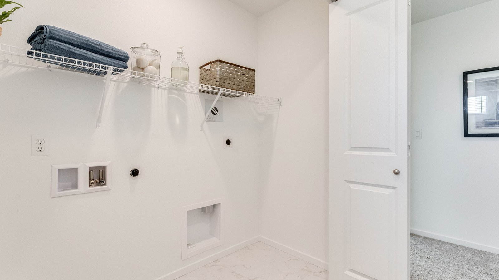 Laundry closet with wire shelves and washer and dryer hookups