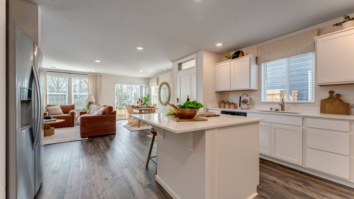 Kitchen with shaker cabinets, quartz counters, stainless steel appliances, pantry, and an island with a breakfast bar