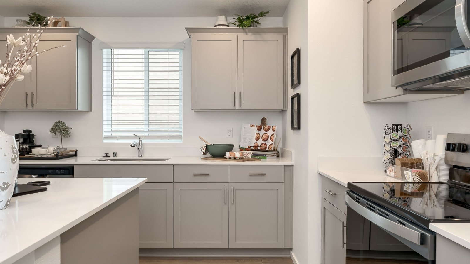 Kitchen with shaker cabinets, quartz counters, stainless steel appliances, pantry, and an island with a breakfast bar