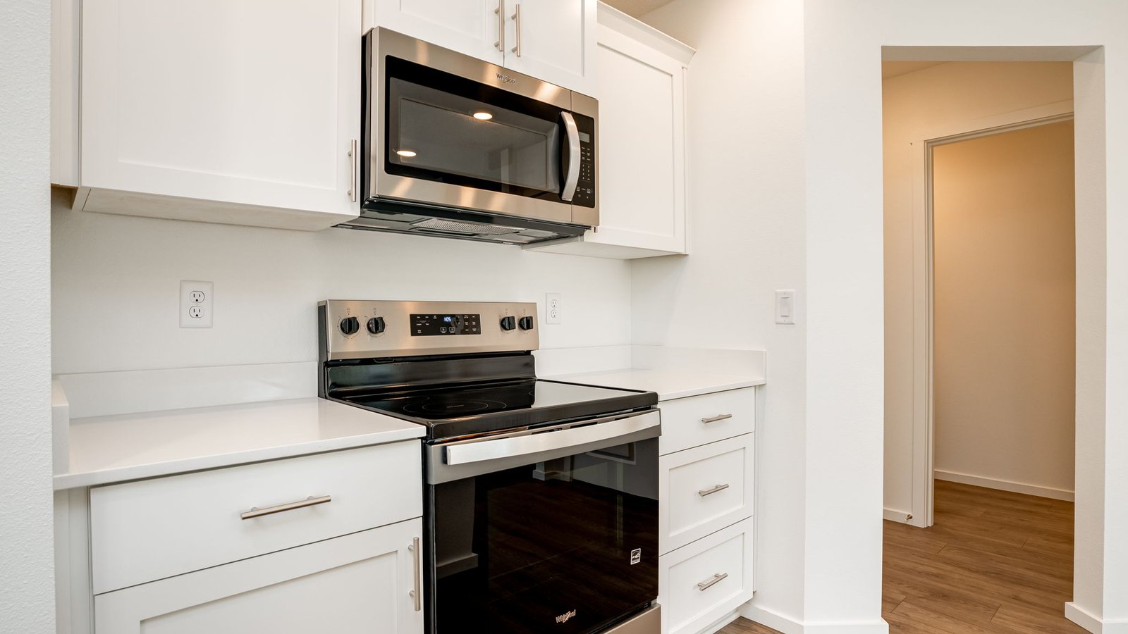Kitchen with shaker cabinets, quartz counters, stainless steel appliances, pantry, and an island with a breakfast bar