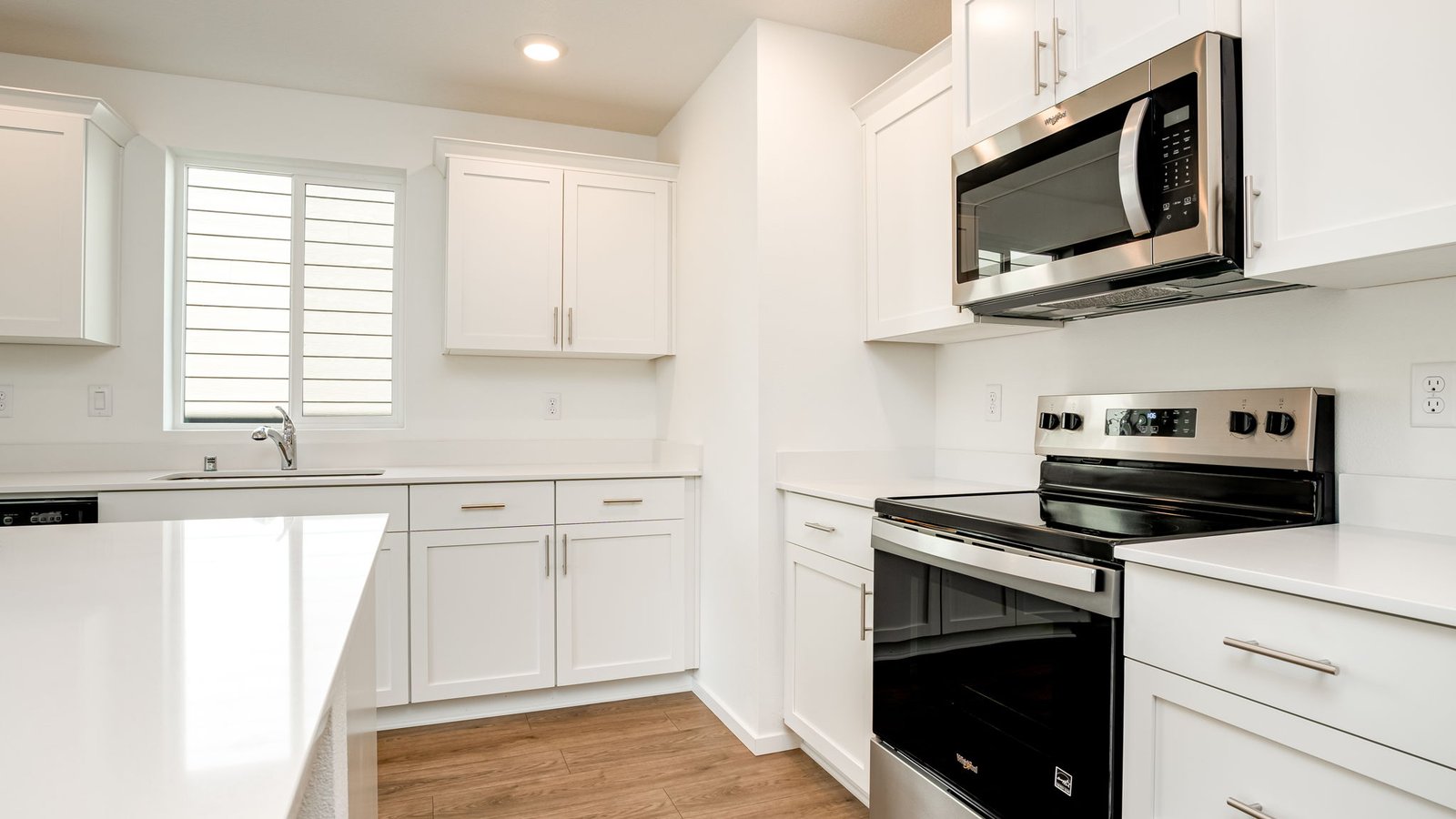 Kitchen with shaker cabinets, quartz counters, stainless steel appliances, pantry, and an island with a breakfast bar