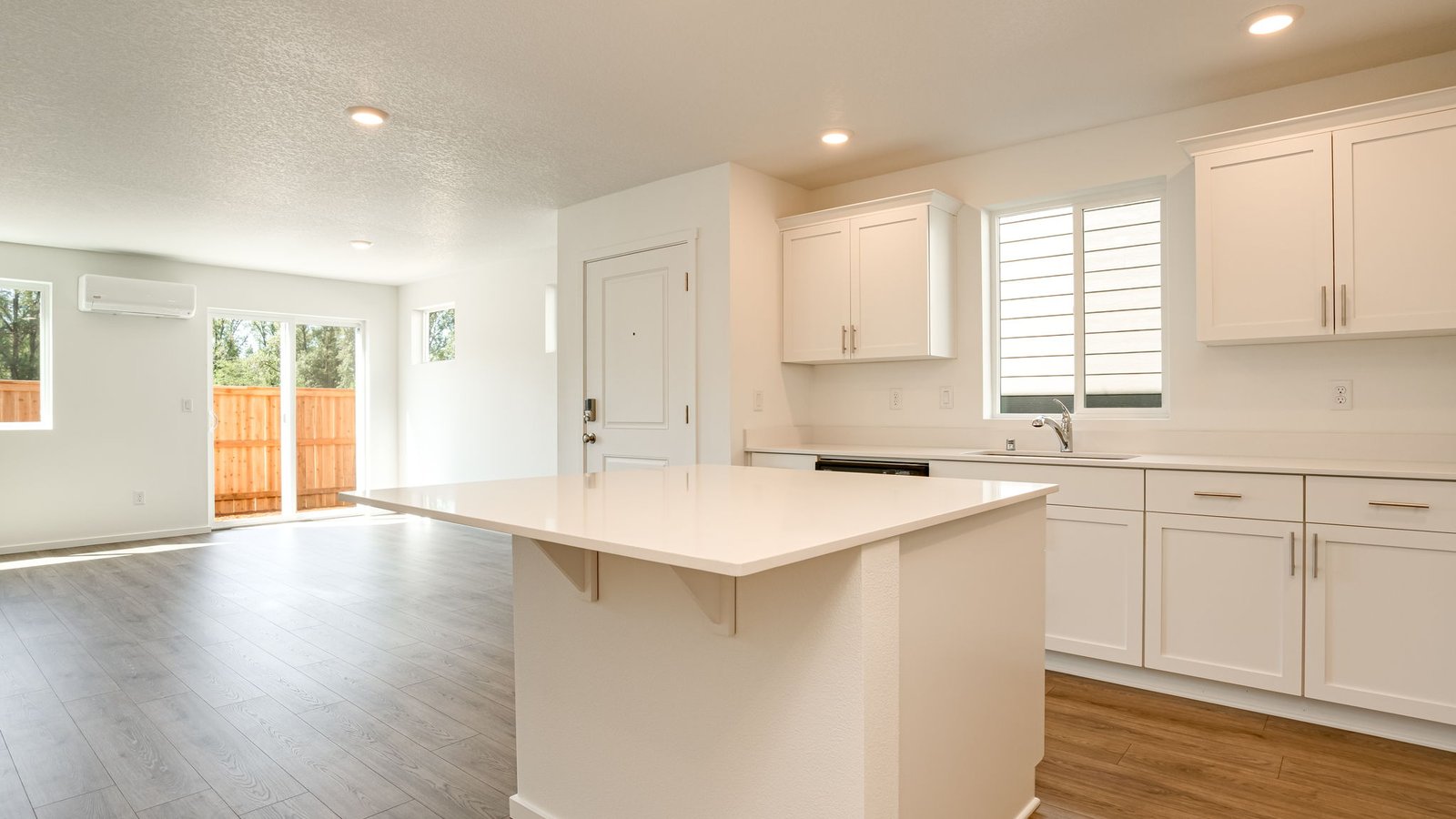 Kitchen with shaker cabinets, quartz counters, stainless steel appliances, pantry, and an island with a breakfast bar