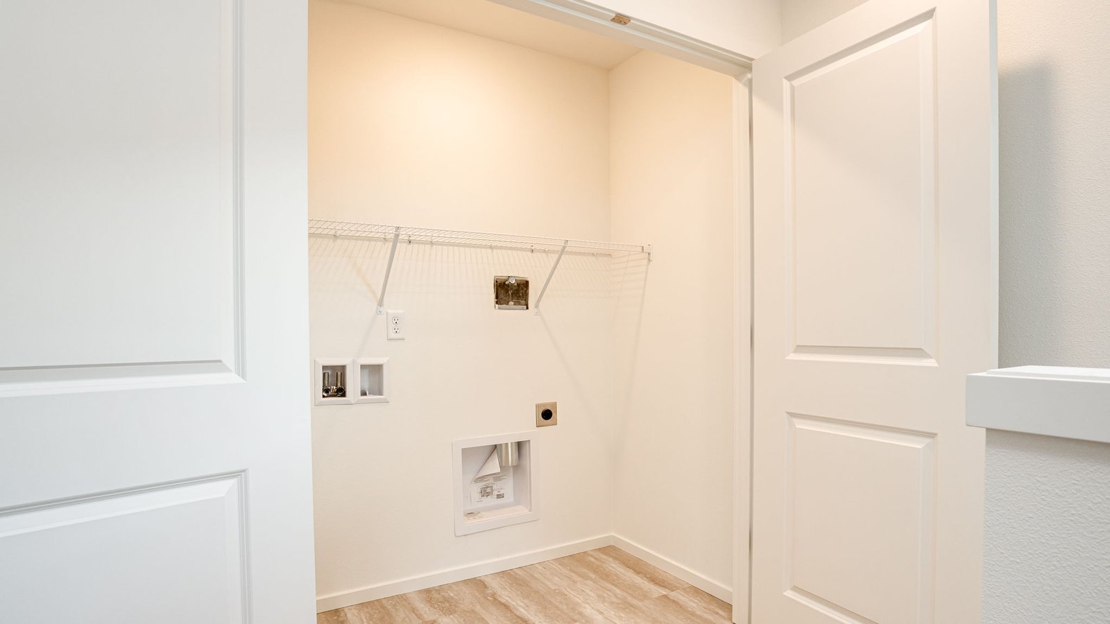 Laundry closet with wire shelves and washer and dryer hookups
