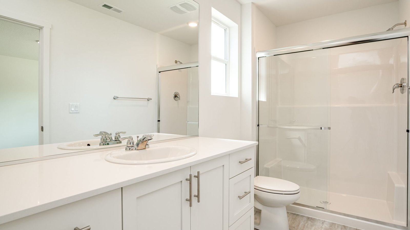 Primary bathroom with quartz counters and a walk-in shower