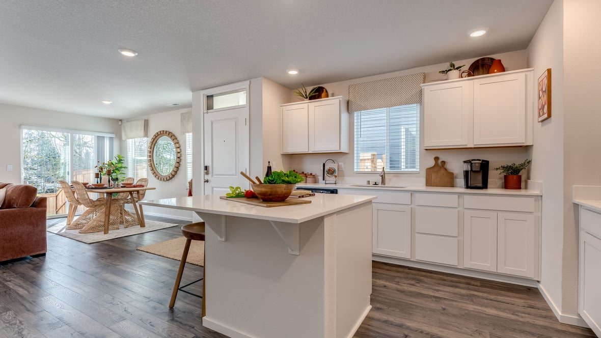 Kitchen with shaker cabinets, quartz counters, stainless steel appliances, pantry, and an island with a breakfast bar