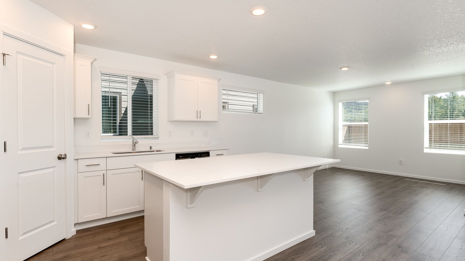 Kitchen with shaker cabinets, quartz counters, stainless steel appliances, pantry, and an island with a breakfast bar