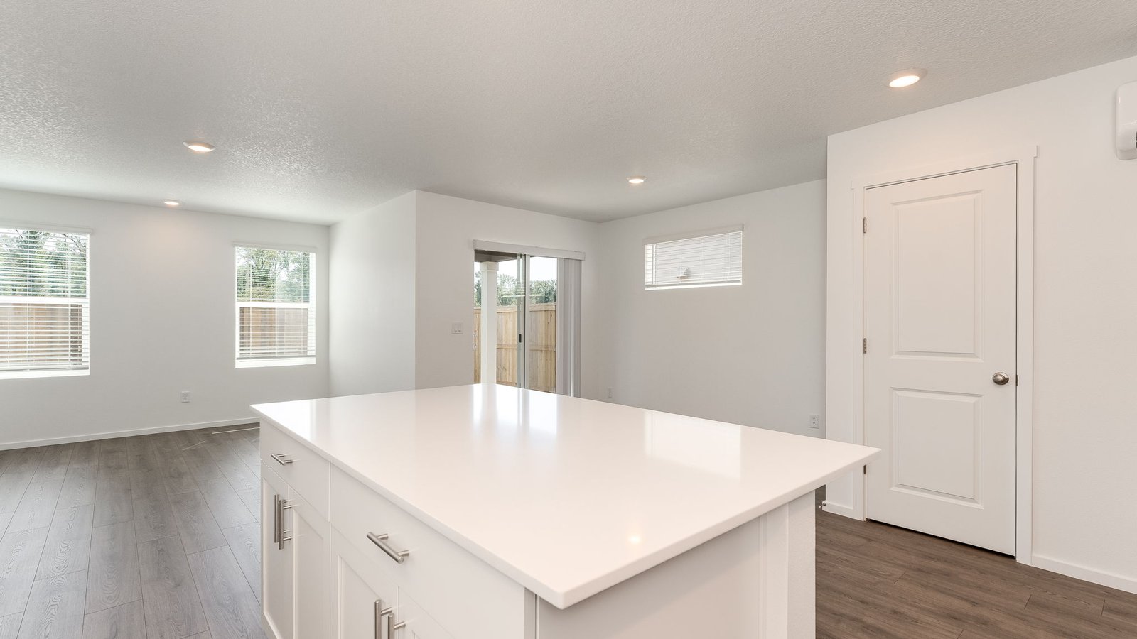 Kitchen with shaker cabinets, quartz counters, stainless steel appliances, pantry, and an island with a breakfast bar