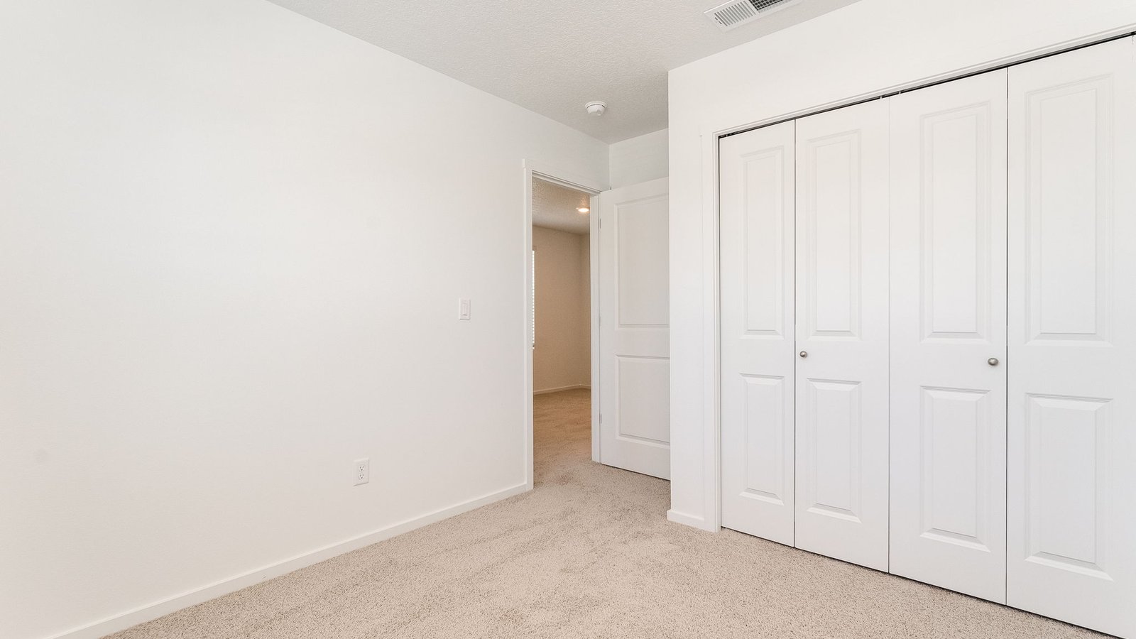 Bedroom with wall-to-wall carpet and a closet