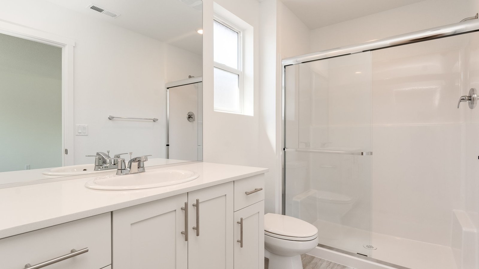 Primary bathroom with quartz counters and a walk-in shower