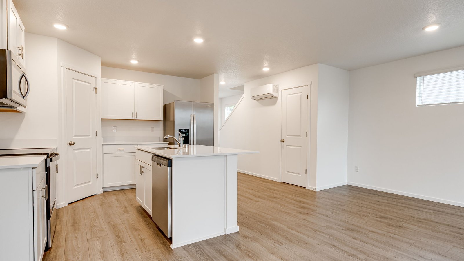 Kitchen with shaker cabinets, quartz counters, stainless steel appliances, pantry, and an island with a breakfast bar
