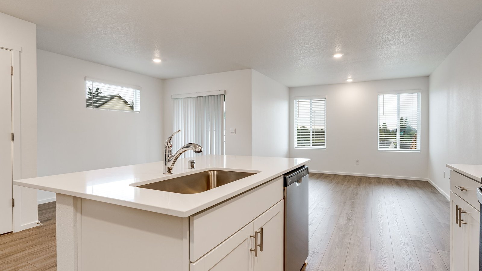 Kitchen with shaker cabinets, quartz counters, stainless steel appliances, pantry, and an island with a breakfast bar