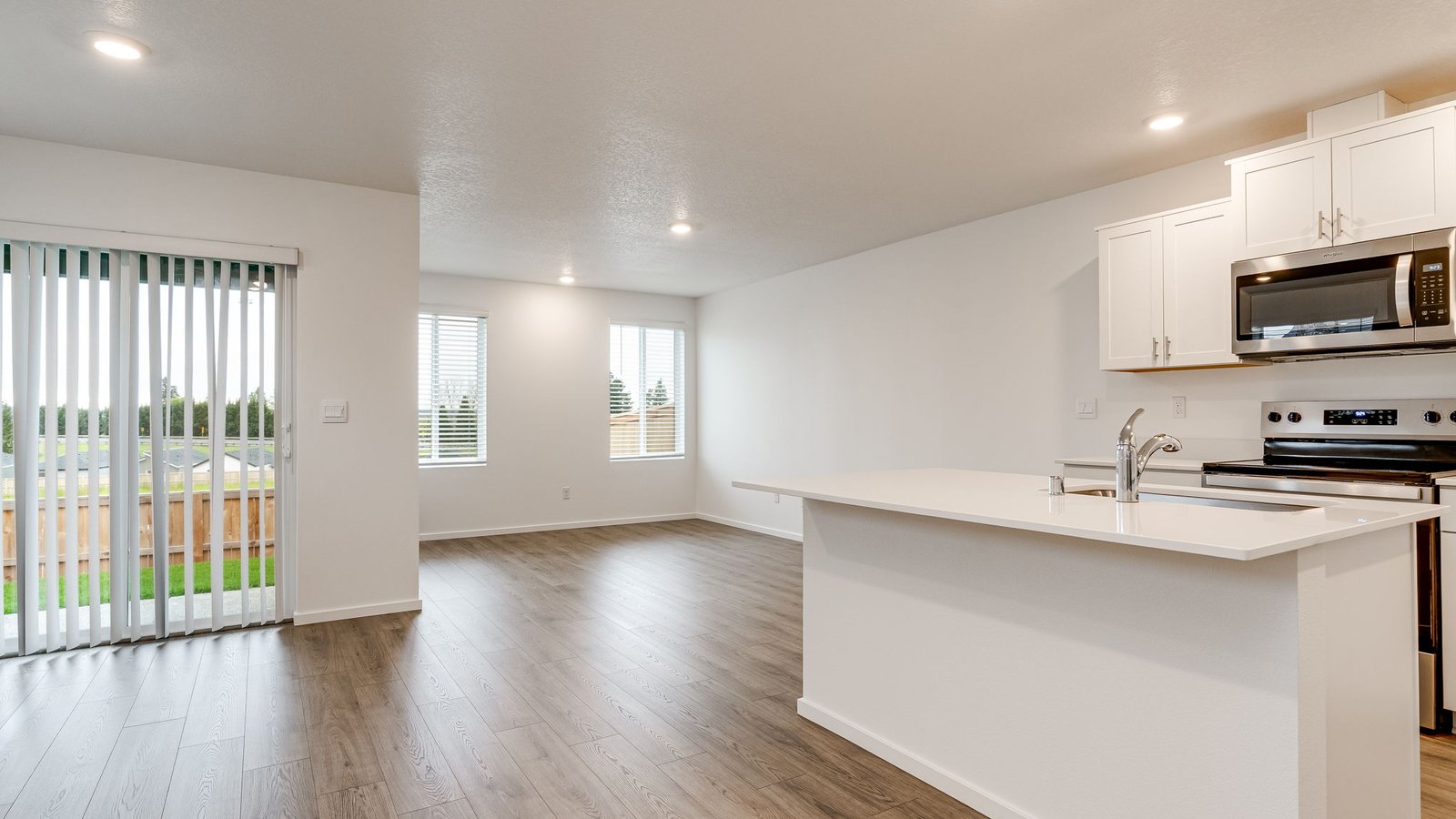 Kitchen with shaker cabinets, quartz counters, stainless steel appliances, pantry, and an island with a breakfast bar