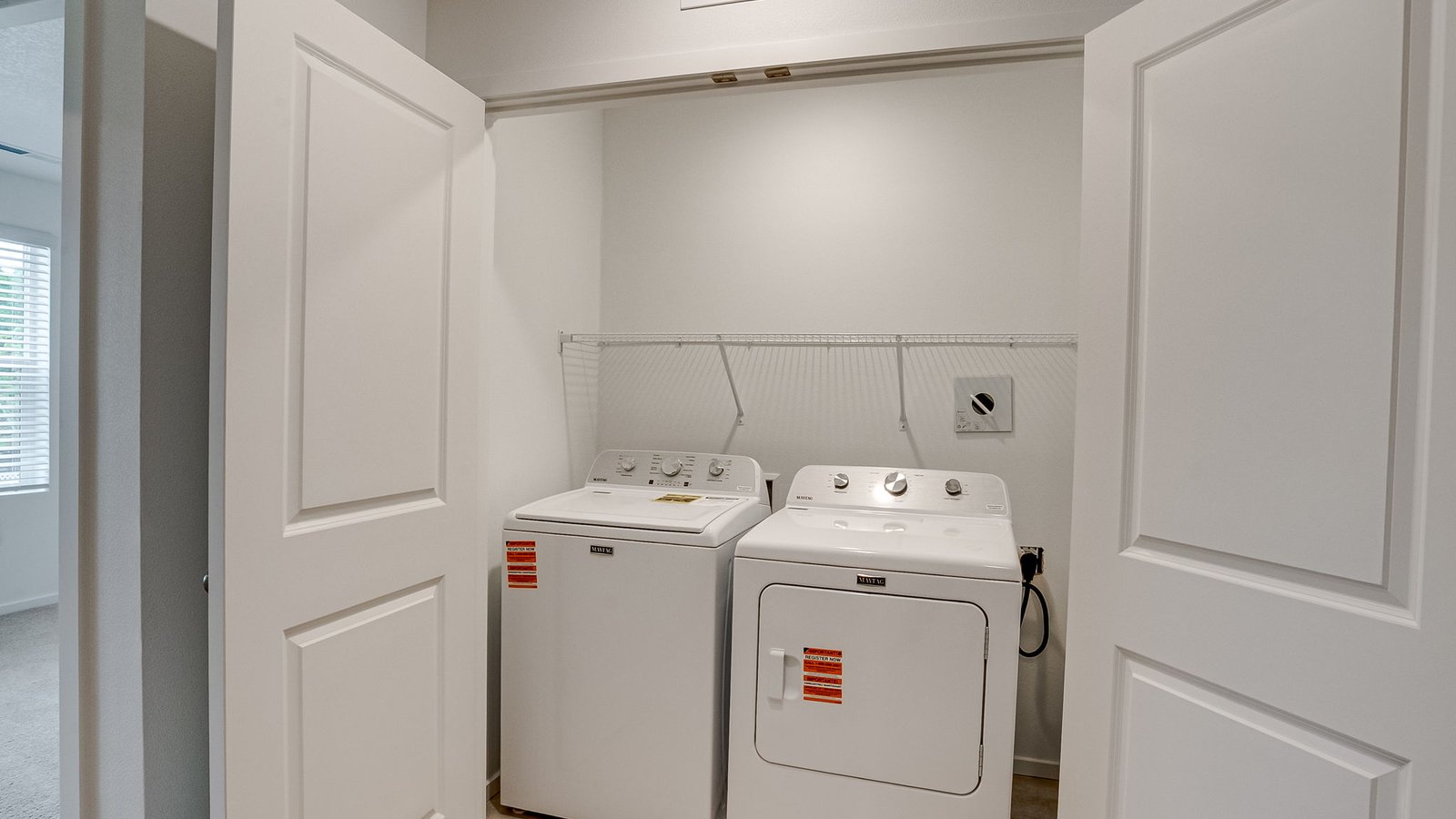 Laundry closet with wire shelves and washer and dryer hookups