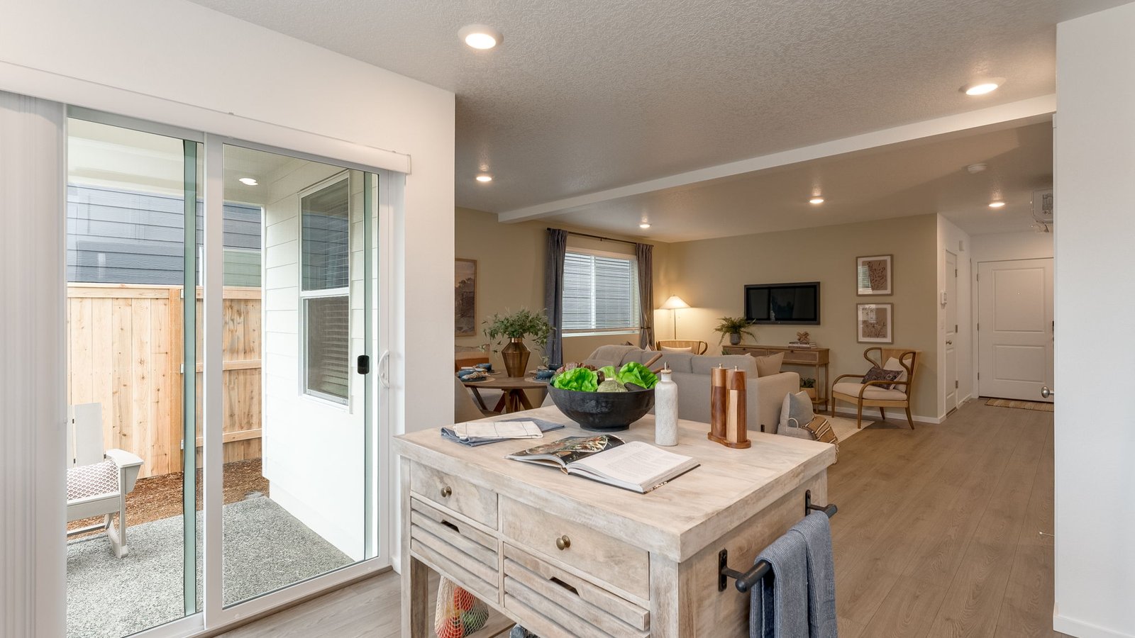 L-shaped kitchen with shaker cabinets, quartz counters, stainless steel appliances, and a pantry