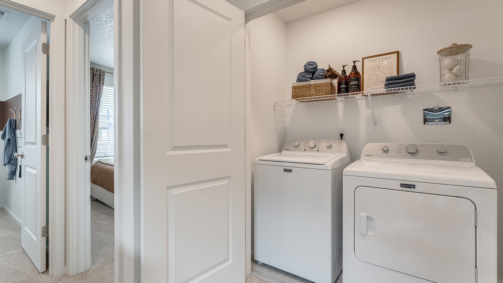 Laundry closet with wire shelves and washer and dryer hookups