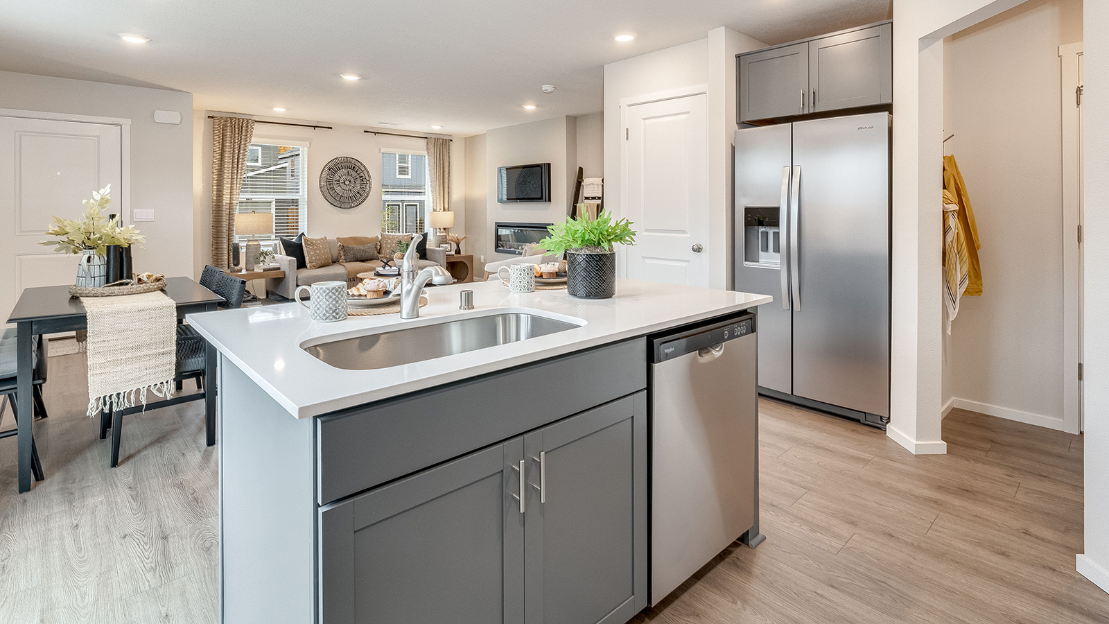 Kitchen with shaker cabinets, quartz counters, stainless steel appliances, pantry, and an island with a breakfast bar