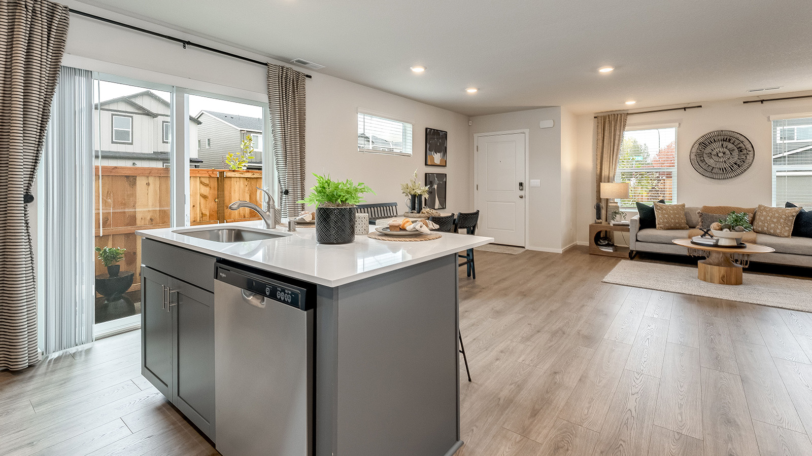 Kitchen with shaker cabinets, quartz counters, stainless steel appliances, pantry, and an island with a breakfast bar