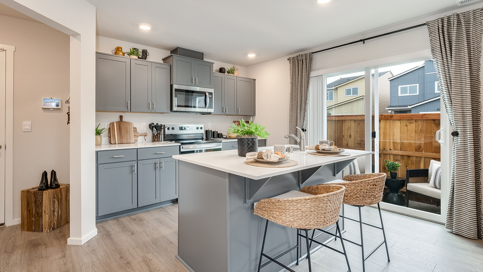 Kitchen with shaker cabinets, quartz counters, stainless steel appliances, pantry, and an island with a breakfast bar