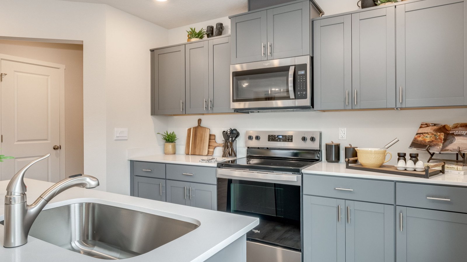 Kitchen with shaker cabinets, quartz counters, stainless steel appliances, pantry, and an island with a breakfast bar