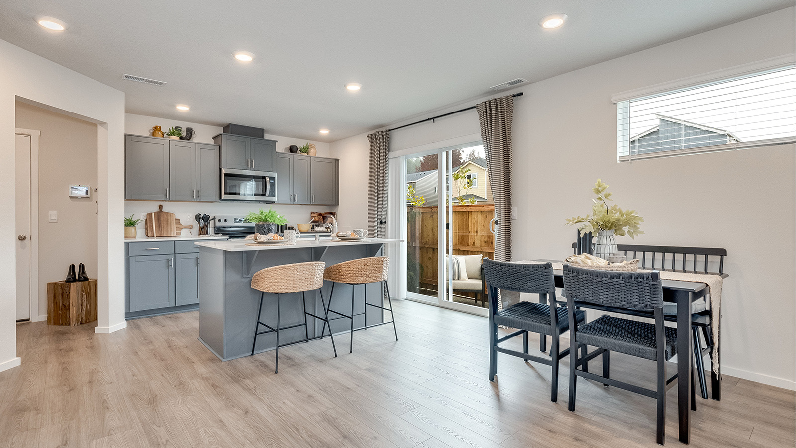 Kitchen with shaker cabinets, quartz counters, stainless steel appliances, pantry, and an island with a breakfast bar