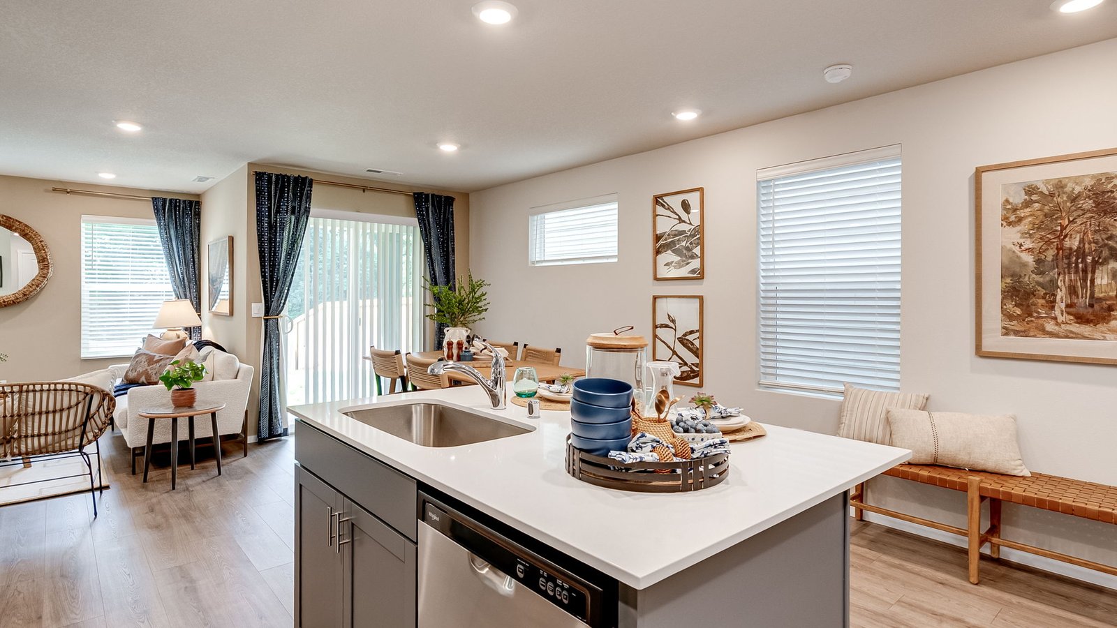 Kitchen with shaker cabinets, quartz counters, stainless steel appliances, pantry, and an island with a breakfast bar