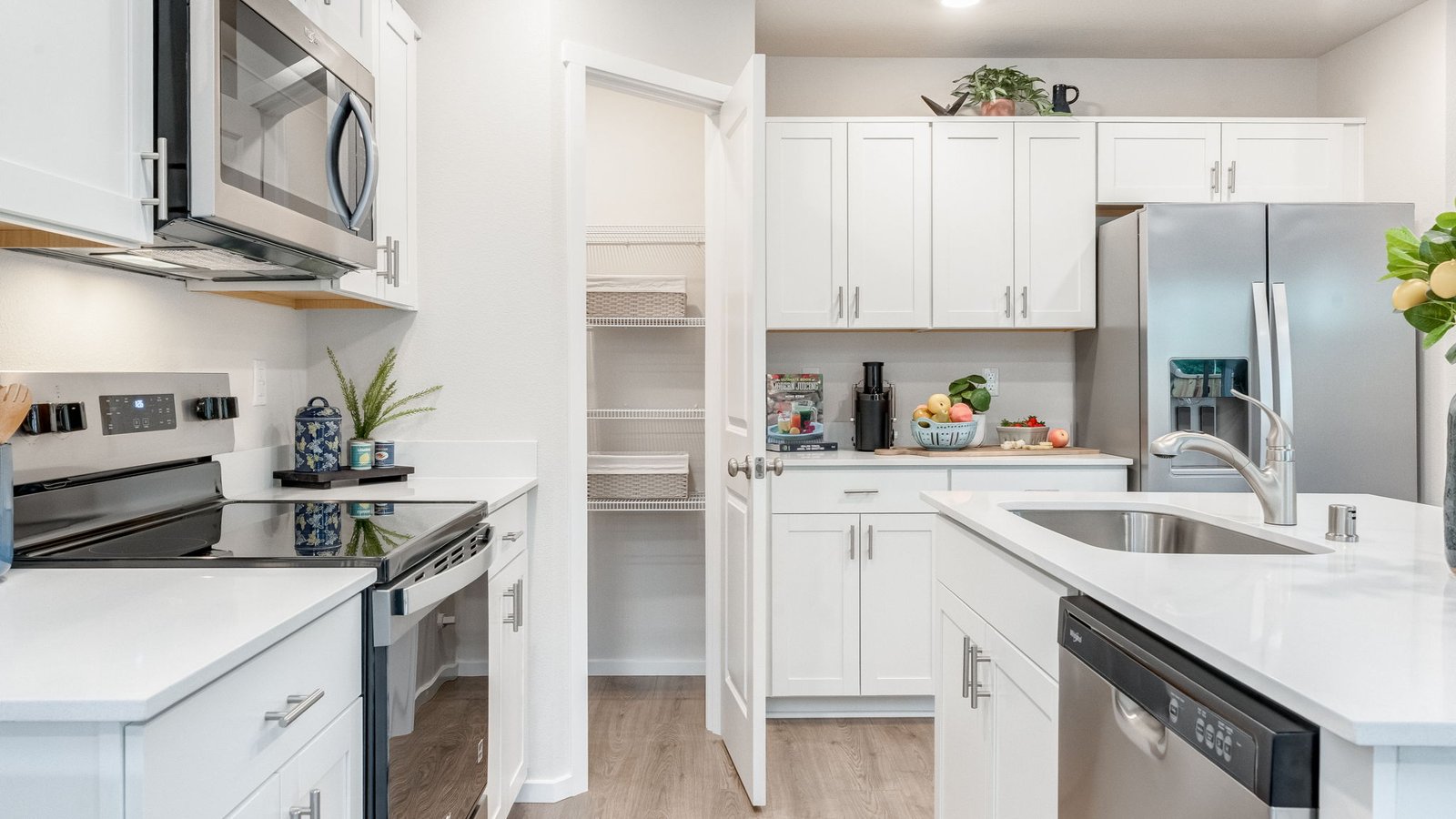 Kitchen with shaker cabinets, quartz counters, stainless steel appliances, pantry, and an island with a breakfast bar