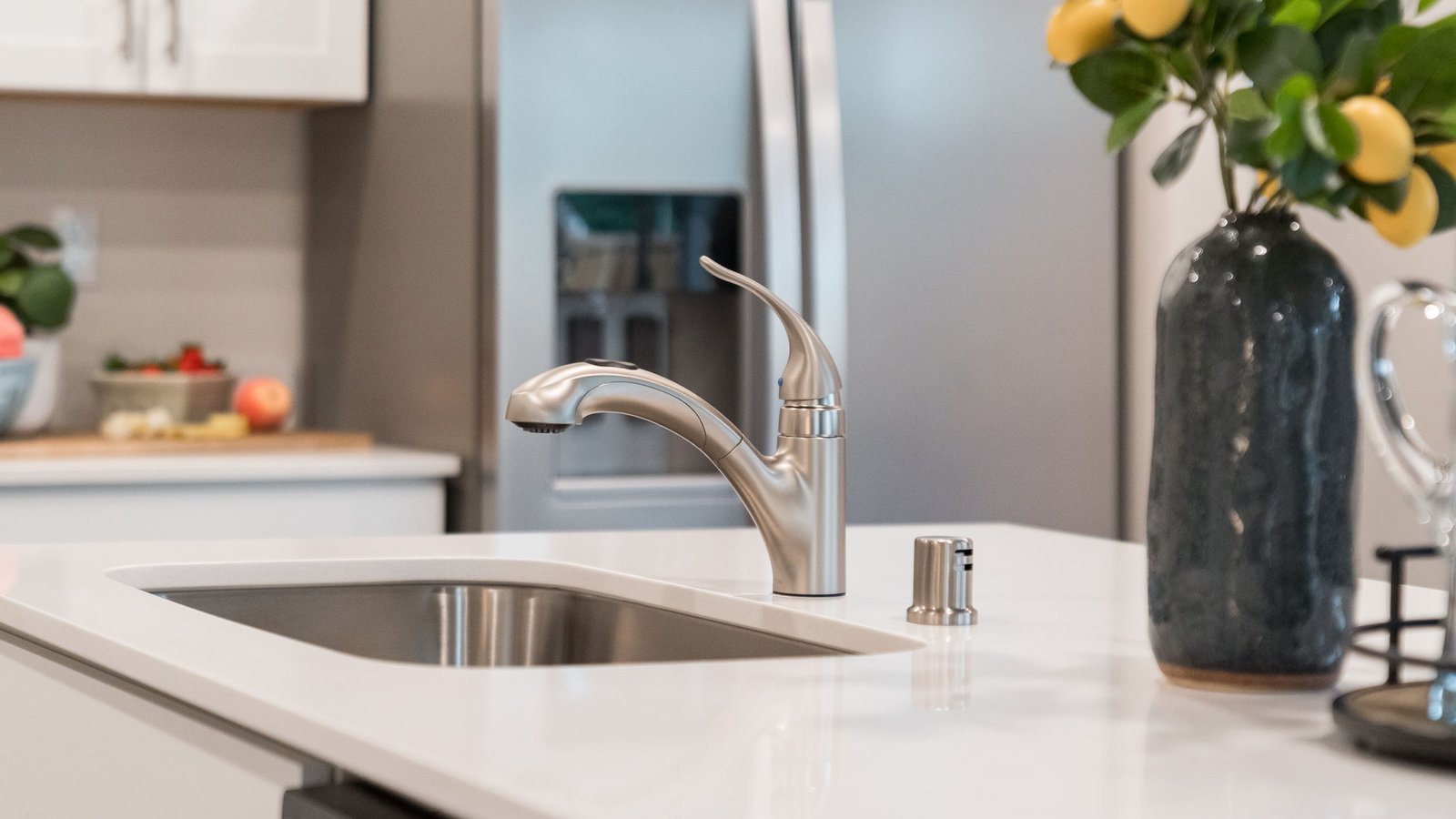 Kitchen with shaker cabinets, quartz counters, stainless steel appliances, pantry, and an island with a breakfast bar