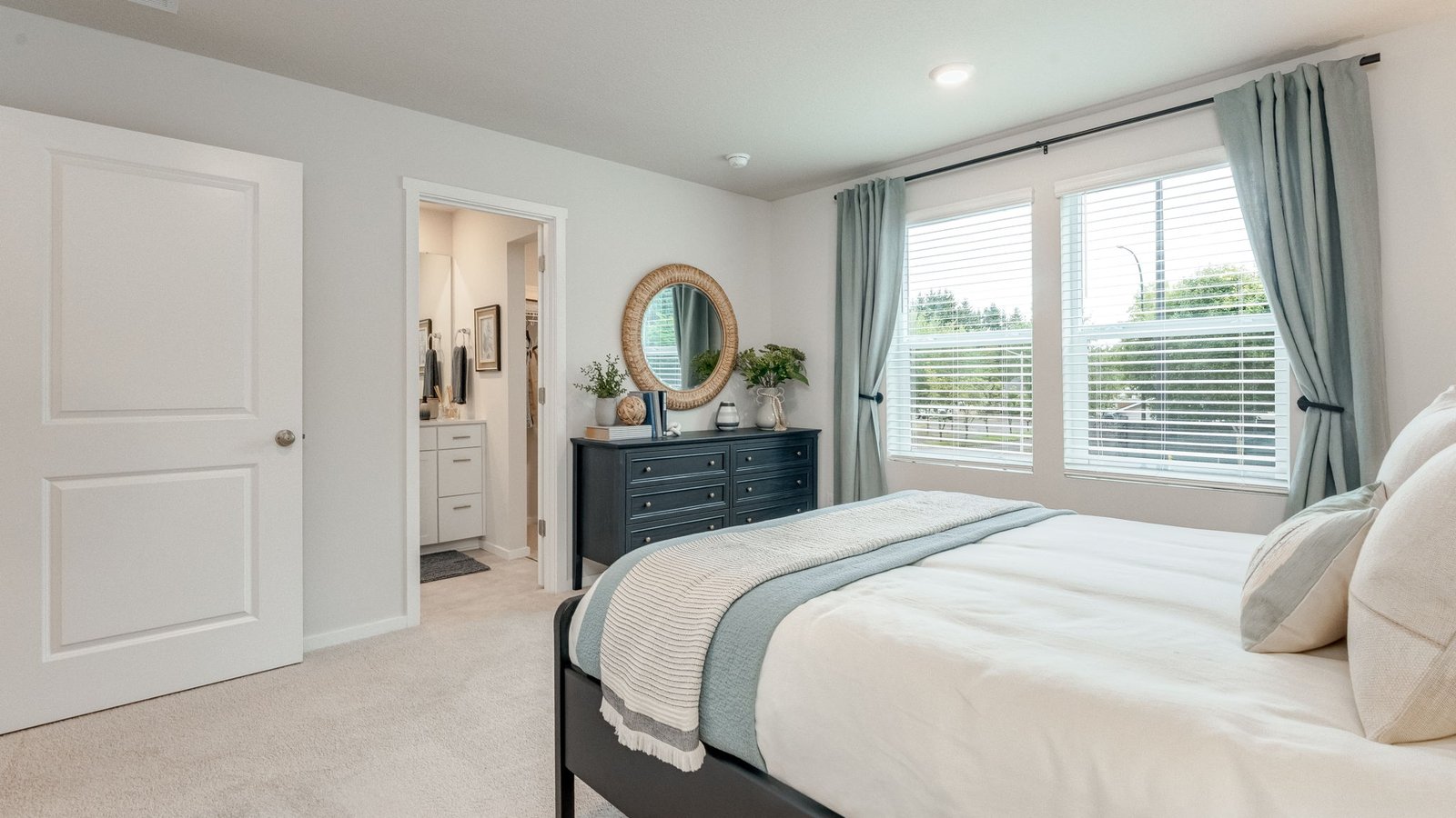 Primary bedroom with wall-to-wall carpet, a walk-in closet and an attached bathroom