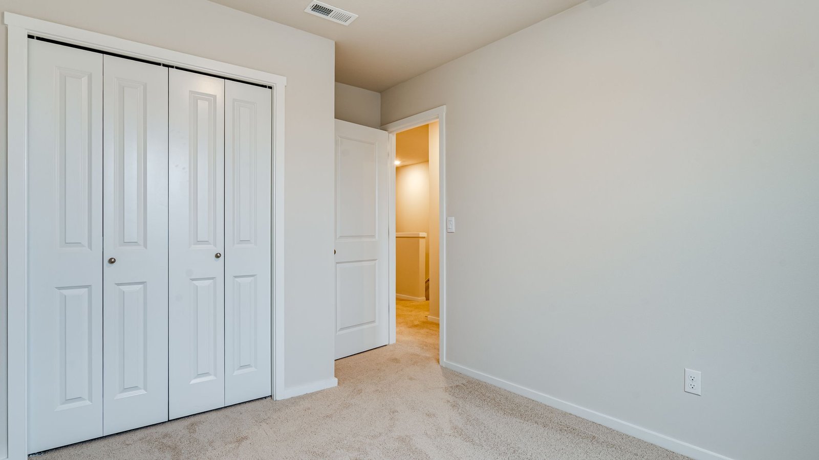Bedroom with wall-to-wall carpet and a closet