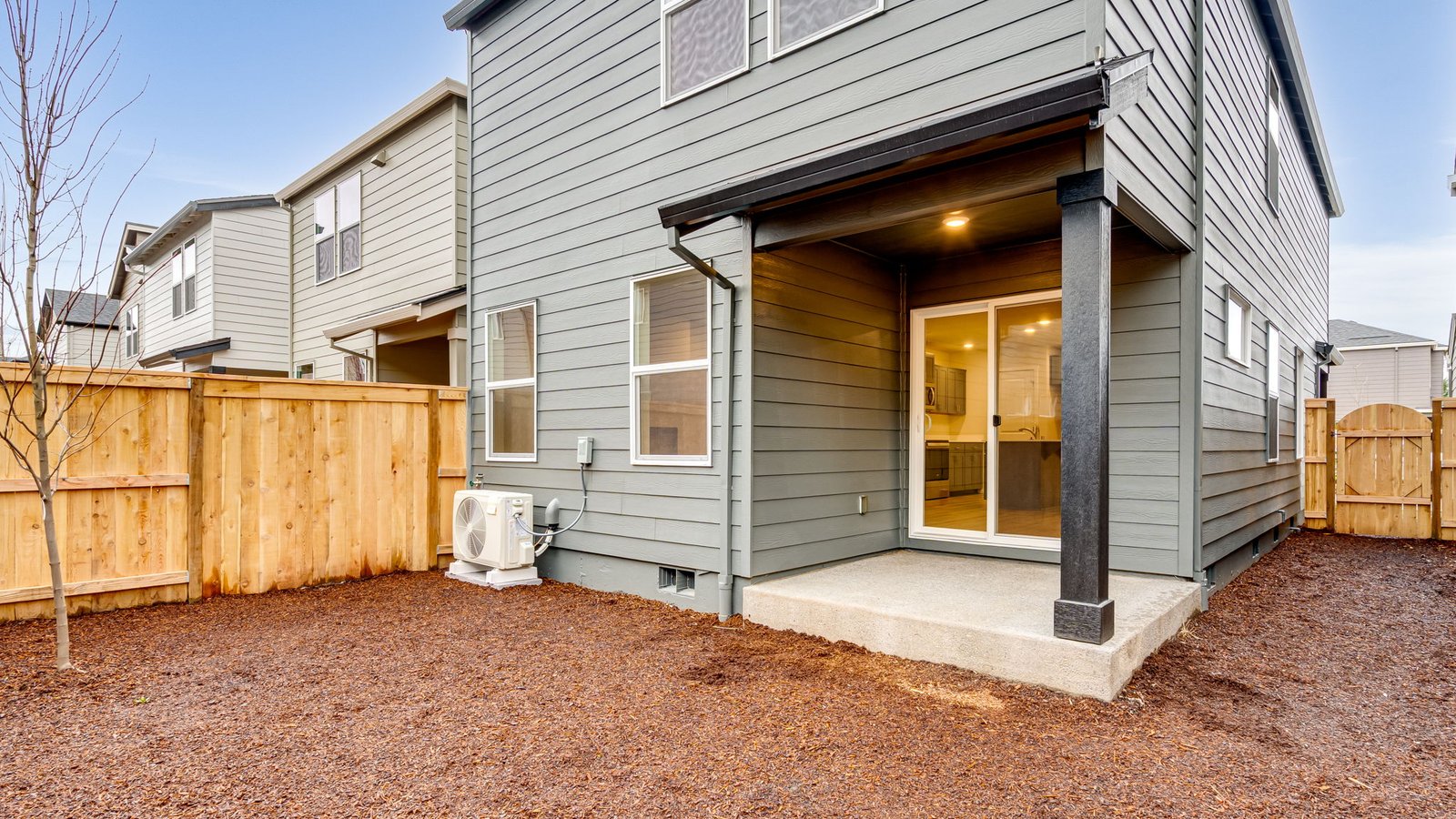 fully fenced backyard with sod lawn and a patio