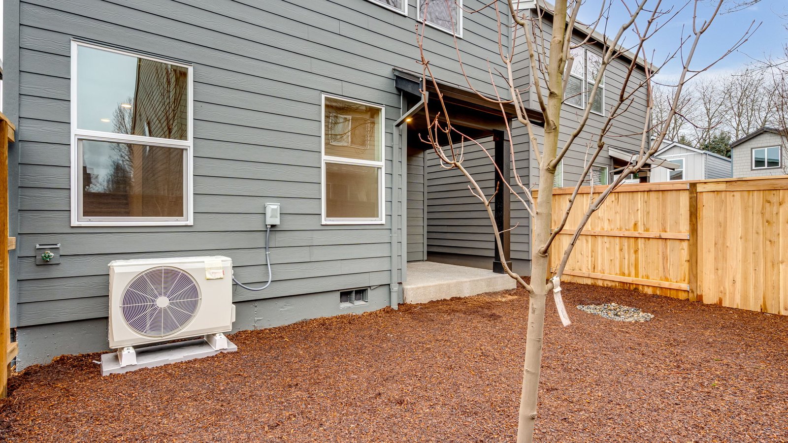 fully fenced backyard with sod lawn and a patio