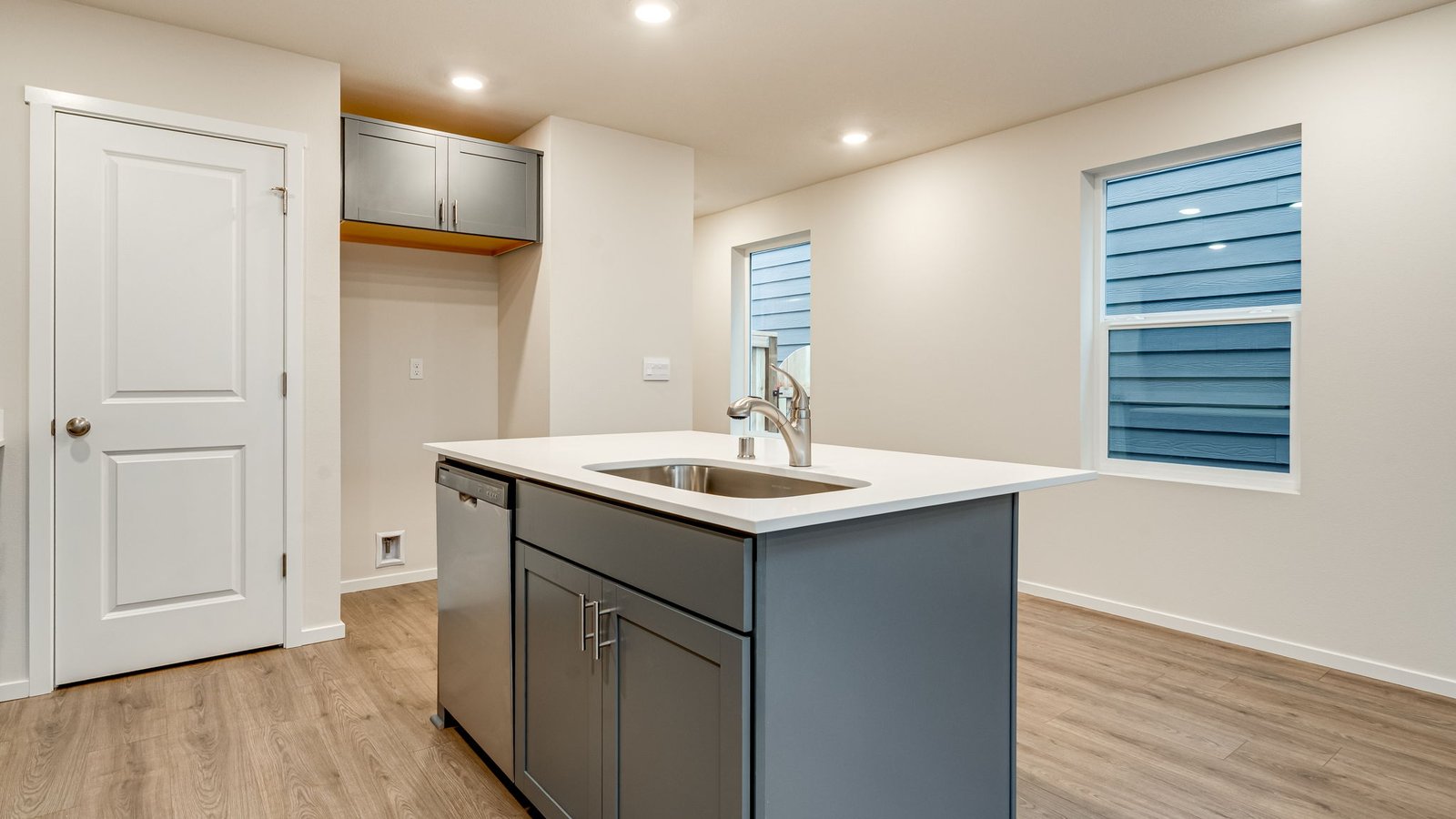 Kitchen with shaker cabinets, quartz counters, stainless steel appliances, pantry, and an island with a breakfast bar