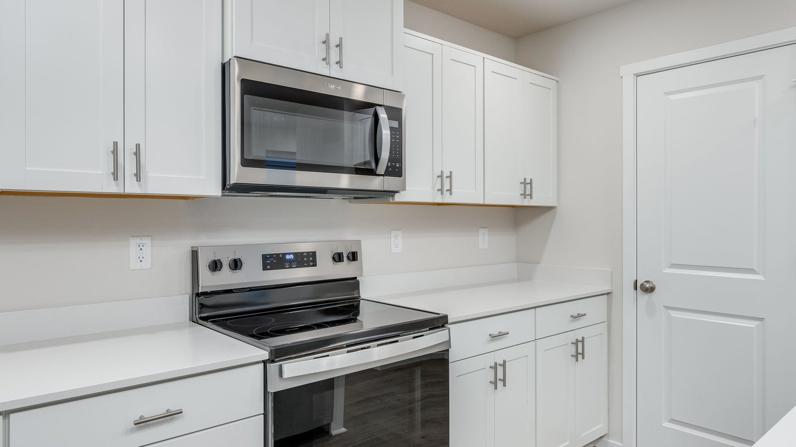 Kitchen with shaker cabinets, quartz counters, stainless steel appliances, pantry, and an island with a breakfast bar