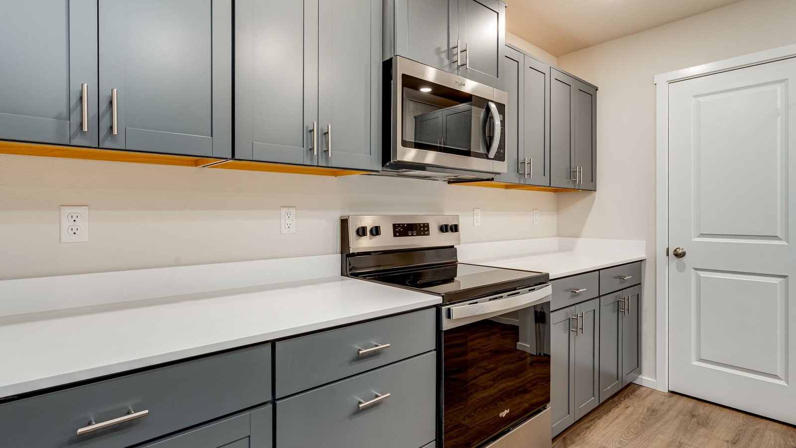 Kitchen with shaker cabinets, quartz counters, stainless steel appliances, pantry, and an island with a breakfast bar