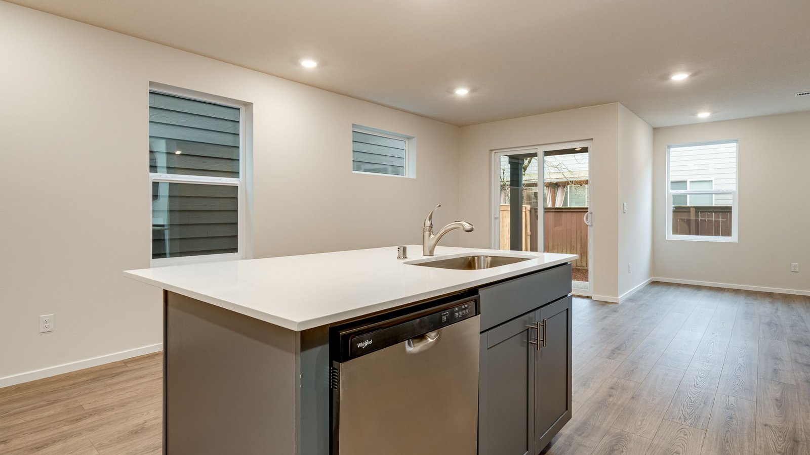 Kitchen with shaker cabinets, quartz counters, stainless steel appliances, pantry, and an island with a breakfast bar