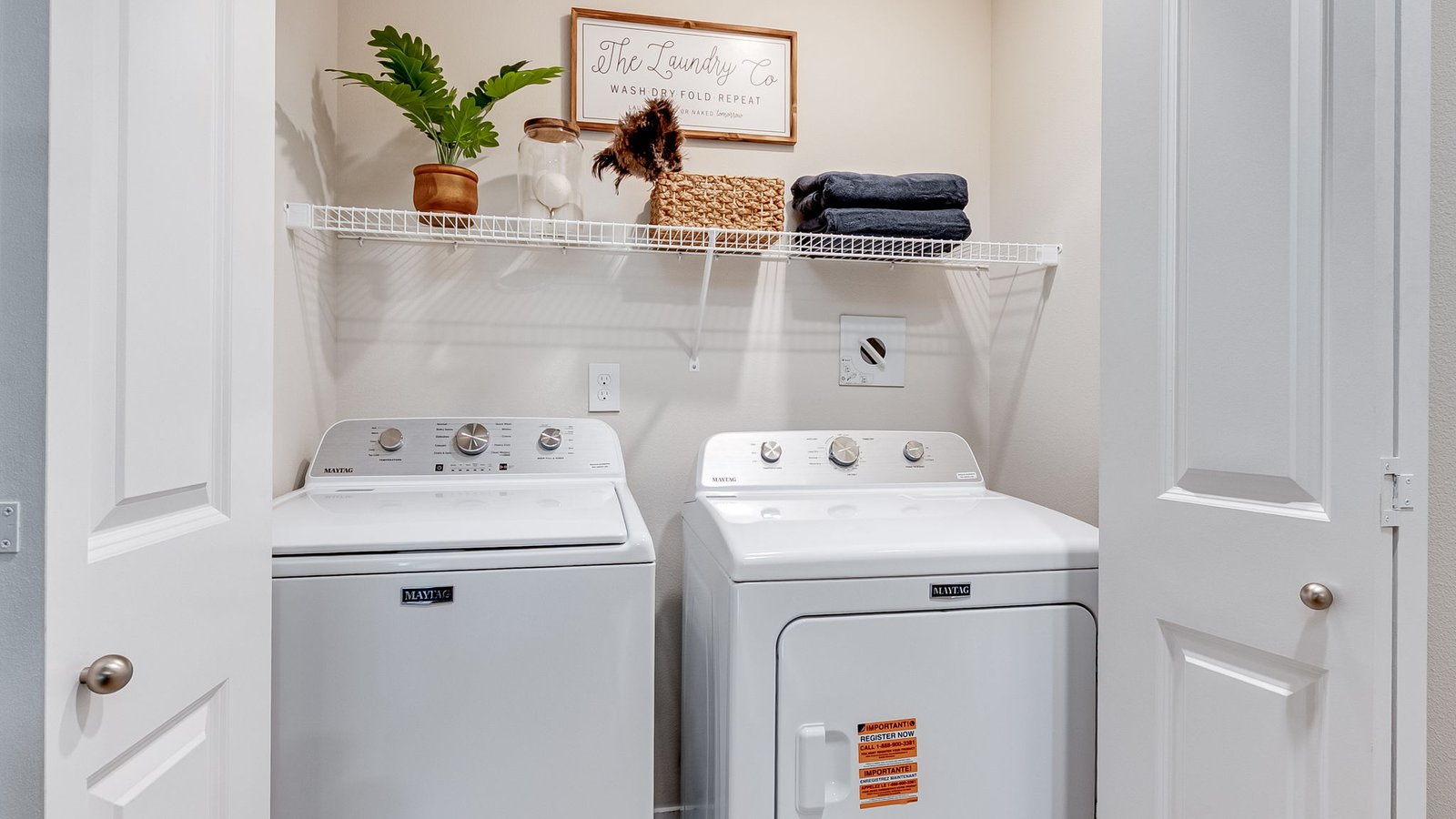 Laundry closet with wire shelves and washer and dryer hookups