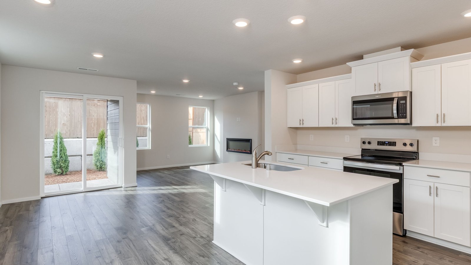 Kitchen with shaker cabinets, quartz counters, stainless steel appliances, pantry, and an island with a breakfast bar