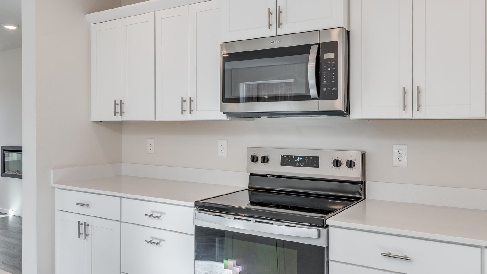 Kitchen with shaker cabinets, quartz counters, stainless steel appliances, pantry, and an island with a breakfast bar