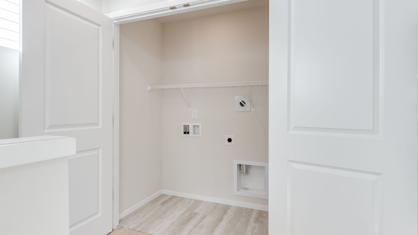 Laundry closet with wire shelves and washer and dryer hookups